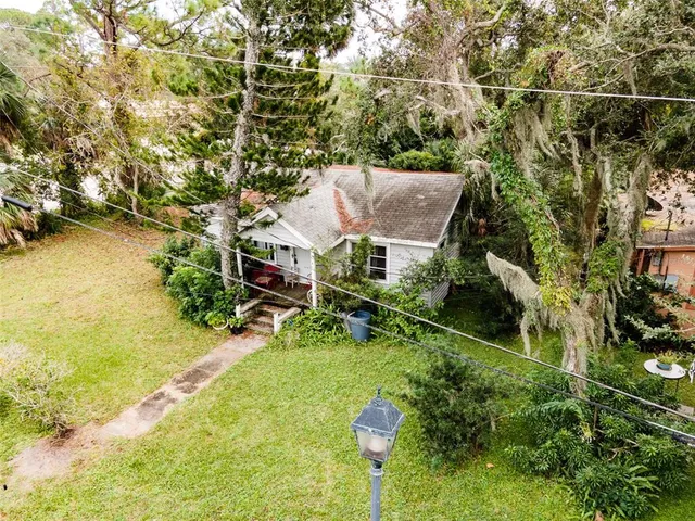 an aerial view of residential house with outdoor space and trees around