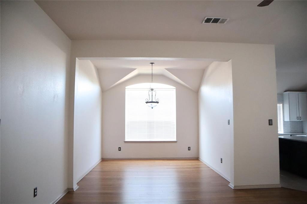6510 Valley Forge Drive Rowlett, TX 75089 - Photo 3 of 14 an empty room with wooden floor cabinet and windows