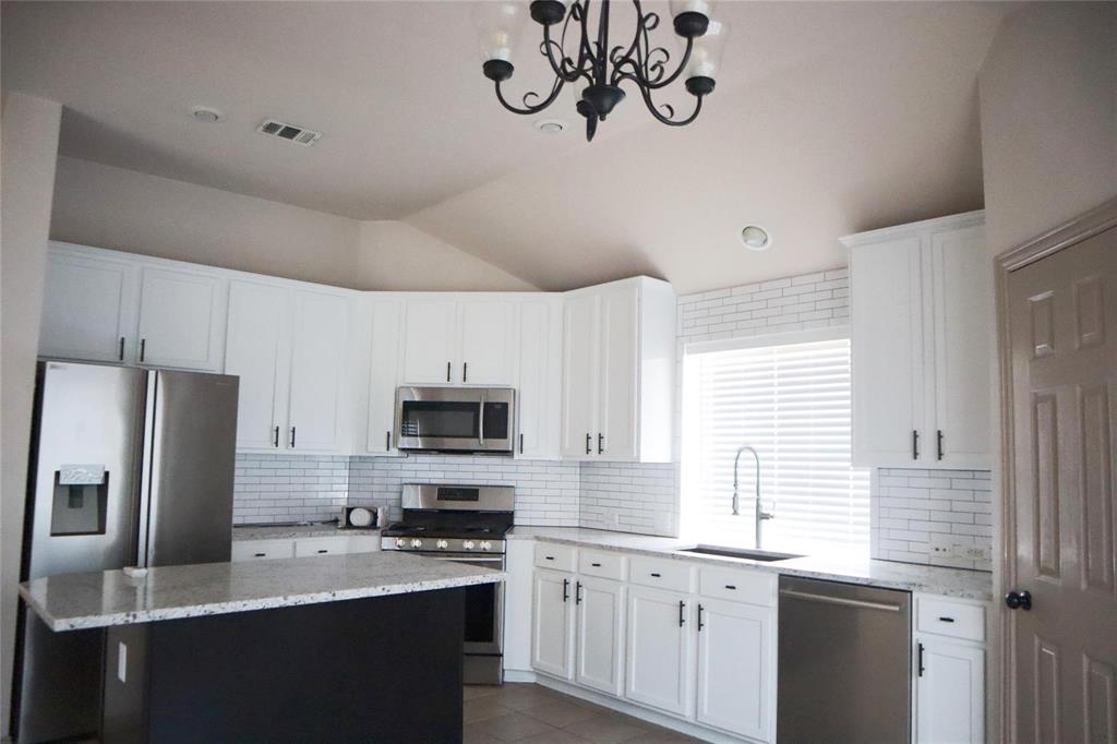 6510 Valley Forge Drive Rowlett, TX 75089 - Photo 9 of 14 a kitchen with stainless steel appliances granite countertop a sink a stove a refrigerator cabinets and a window