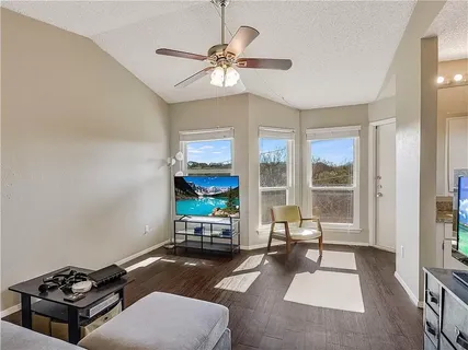 a living room with furniture a floor to ceiling window and a flat screen tv