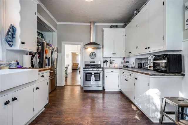 a kitchen with granite countertop white cabinets and stainless steel appliances