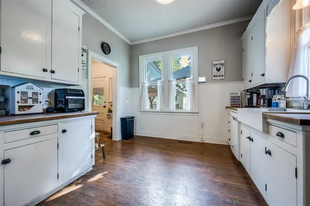 a kitchen with cabinets wooden floor and a window