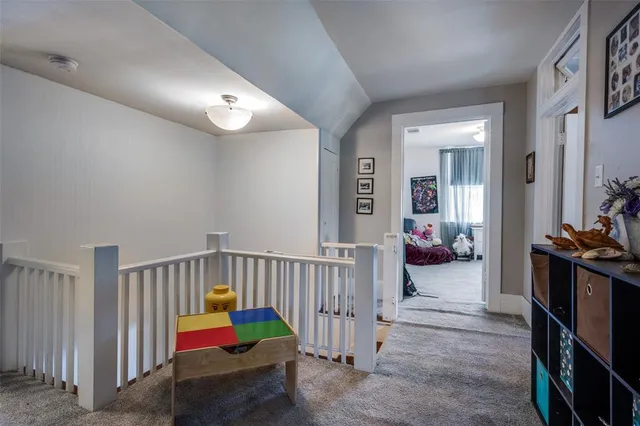 a bedroom with bed and a flat tv screen on the dresser