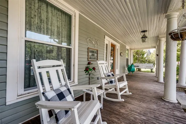 a view of a patio with table and chairs with wooden floor and fence