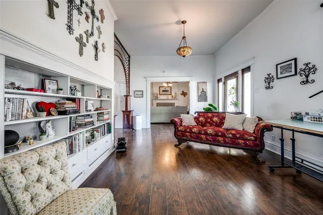 a living room with furniture hard wood floor and a book shelf