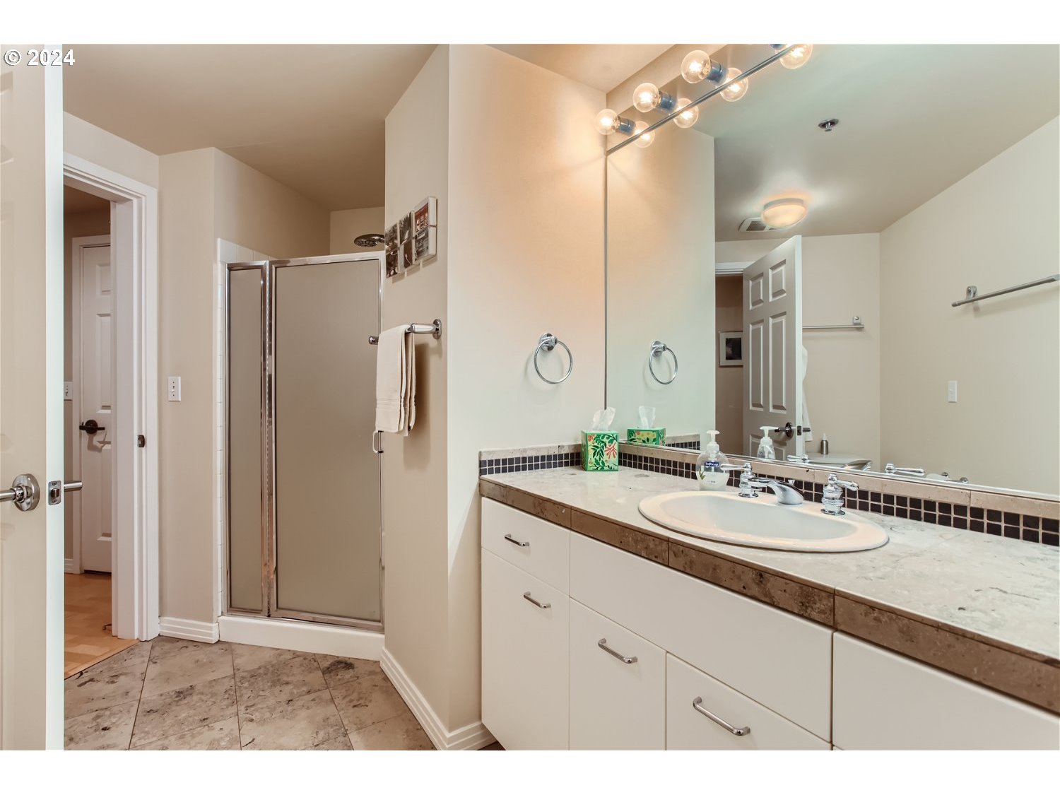 1132 Southwest 19th Avenue, Unit 309 Portland, OR 97205 - Photo 21 of 32 a bathroom with a sink vanity granite shower and a mirror