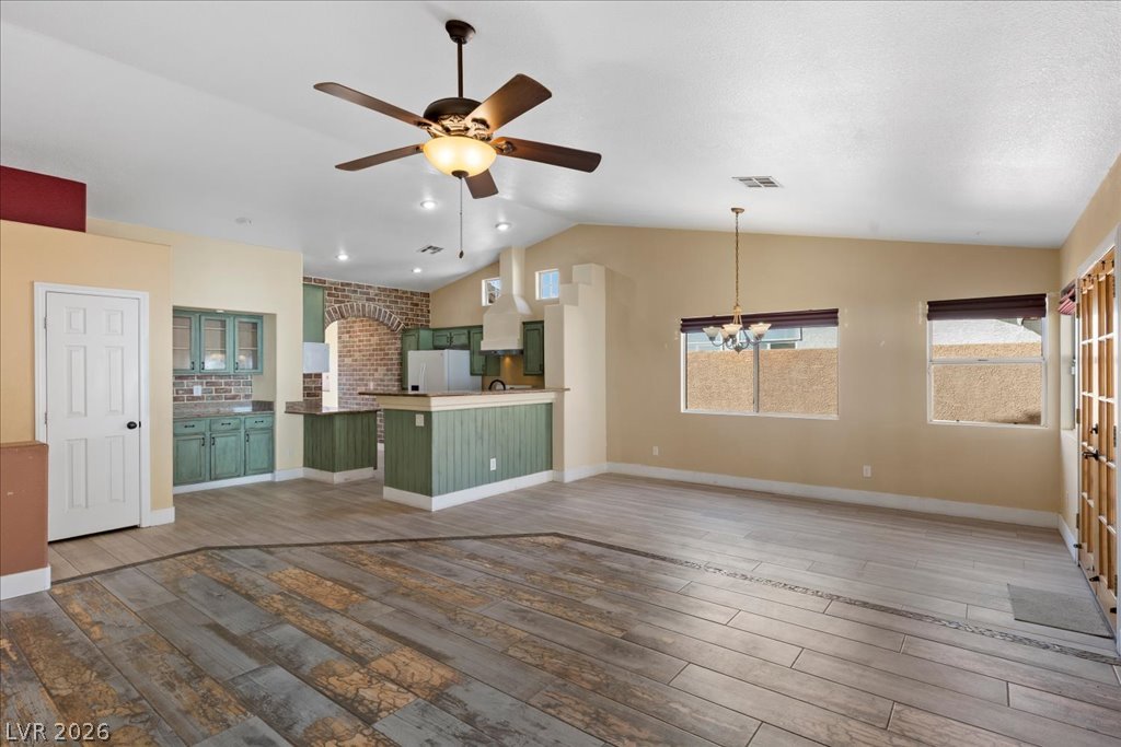 120 Ringlore Road Henderson, NV 89015 - Photo 11 of 58 Vaulted ceilings and wood-look tile floors define this airy, open-concept living space.