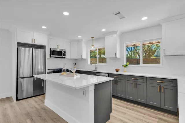 a kitchen with stainless steel appliances granite countertop a sink stove and refrigerator