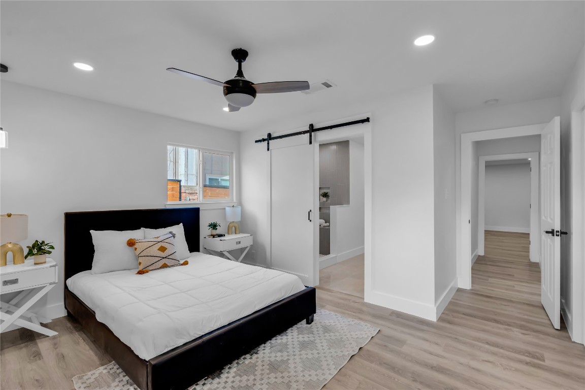 11602 Big Trail Austin, TX 78759 - Photo 16 of 27 a bedroom with a bed and a chandelier