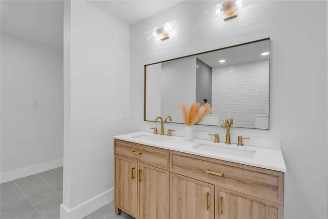 a bathroom with a sink a light fixture a vanity and a toilet