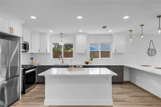 a kitchen with a sink cabinets and wooden floor