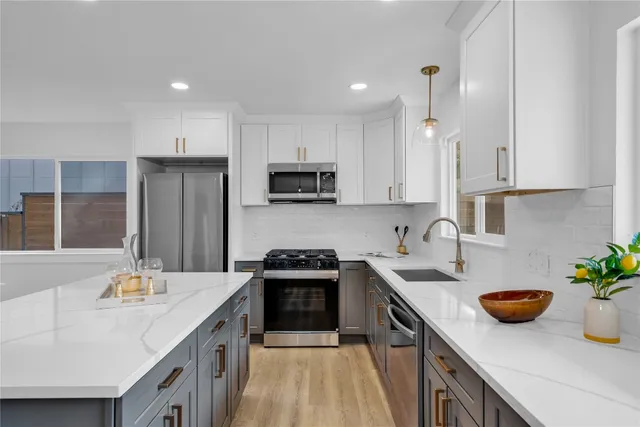 a kitchen with a sink a counter top space stainless steel appliances and cabinets