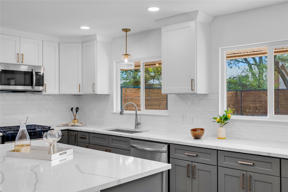11602 Big Trail Austin, TX 78759 - Photo 6 of 27 a kitchen with stainless steel appliances a sink a microwave a stove and white cabinets
