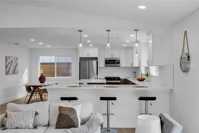 a living room with furniture a rug and a floor to ceiling window