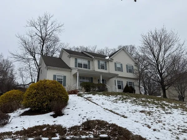 a front view of a house with a yard covered in snow