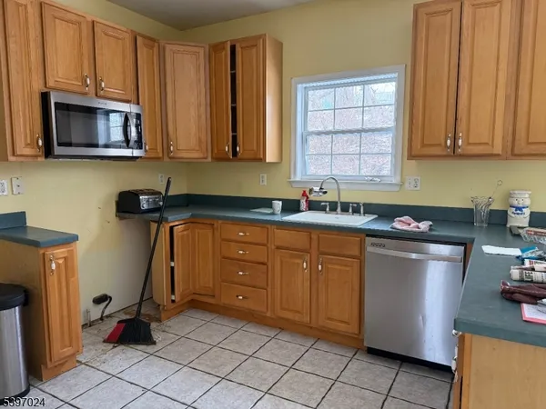 a kitchen with stainless steel appliances granite countertop a sink a stove a microwave a refrigerator and cabinets