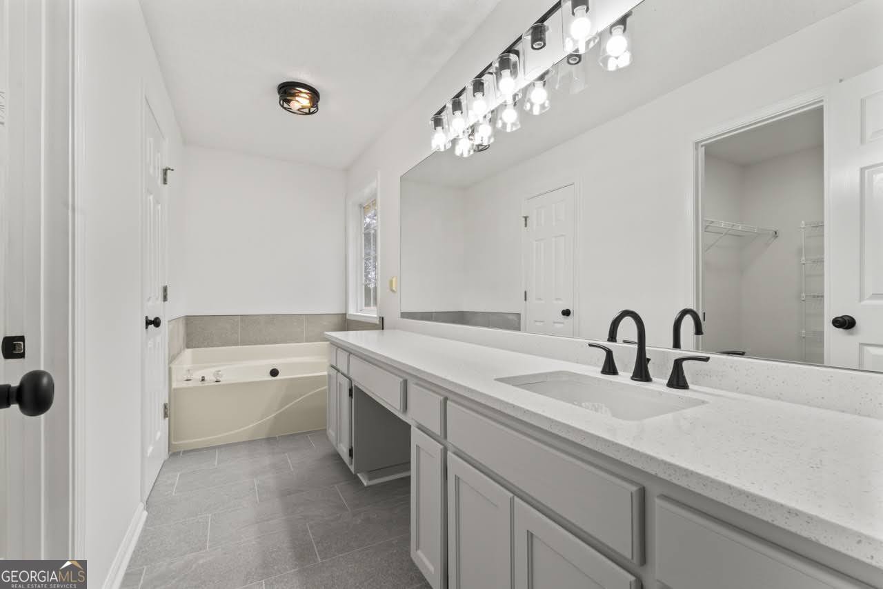 2093 Highway 36 Milner, GA 30257 - Photo 12 of 18 a bathroom with a sink a large mirror and a bathtub