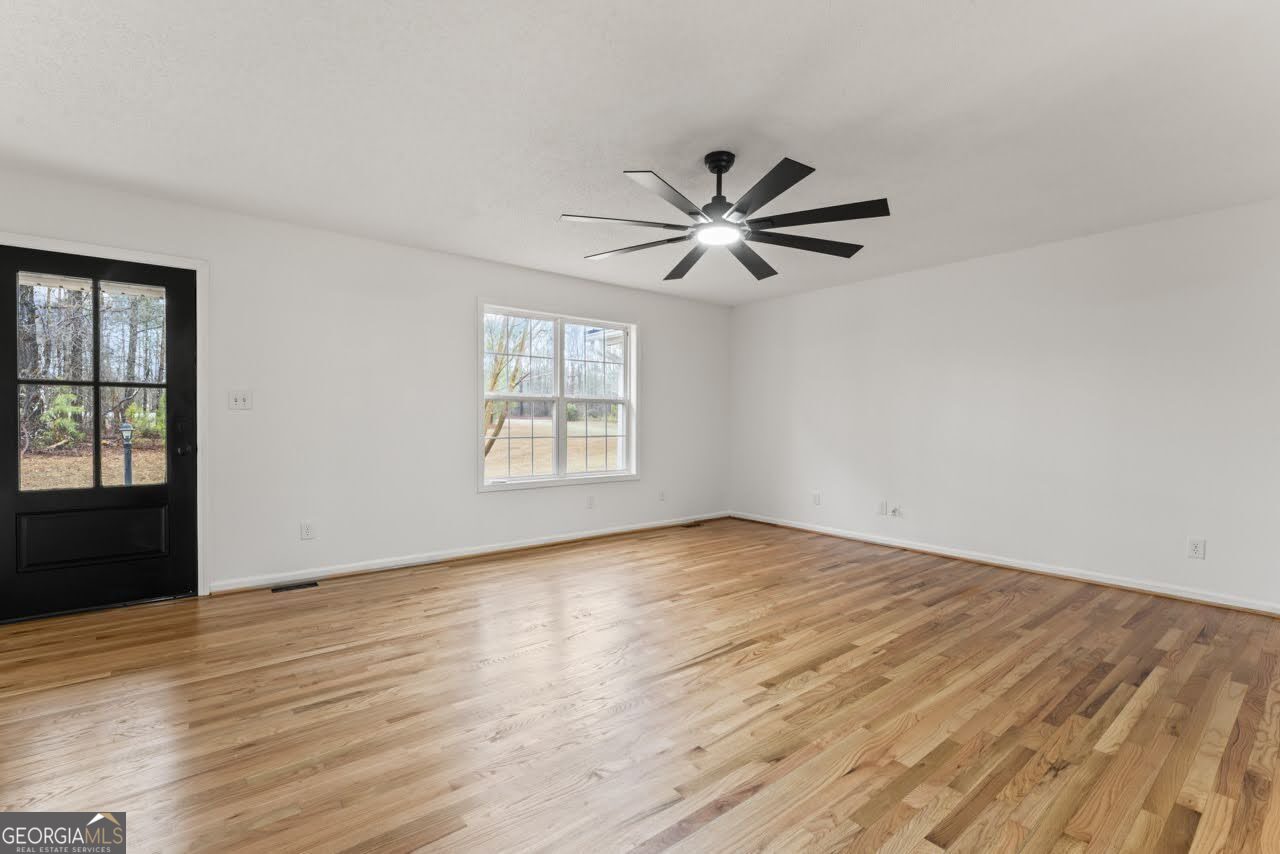 2093 Highway 36 Milner, GA 30257 - Photo 4 of 18 an empty room with wooden floor and windows