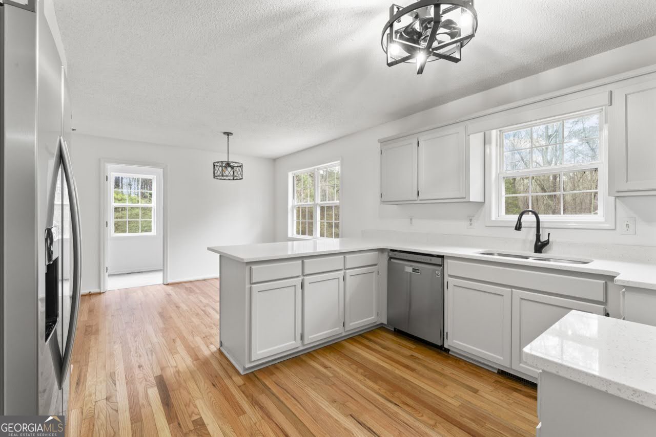 2093 Highway 36 Milner, GA 30257 - Photo 6 of 18 a kitchen with stainless steel appliances granite countertop a sink cabinets a stove and a window