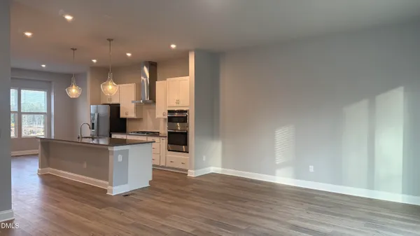 a kitchen with stainless steel appliances kitchen island wooden floors and view living room