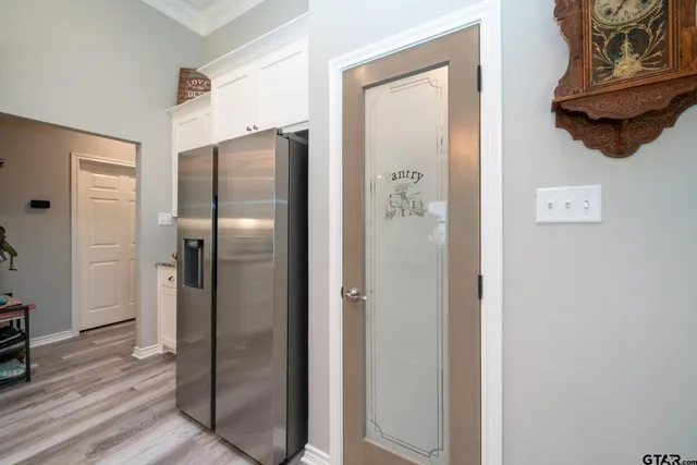 a bathroom with a glass shower door and a wooden floor