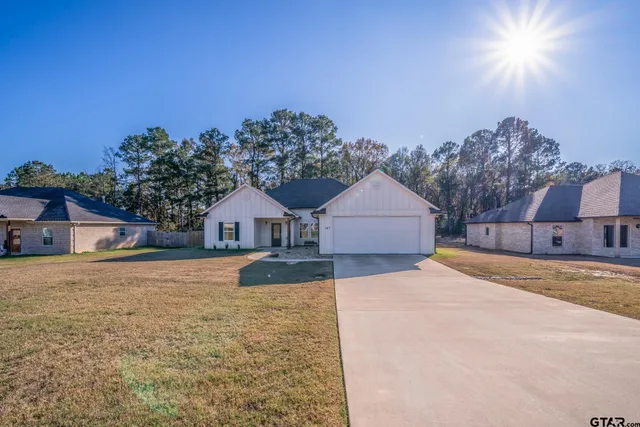 a front view of a house with a yard and trees