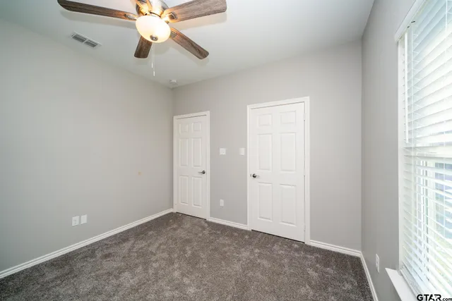 a bathroom with a granite countertop sink a toilet and a mirror