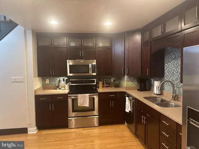 a kitchen with stainless steel appliances granite countertop a sink and a stove top oven