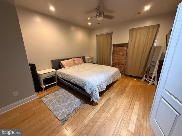 a bedroom with a bed and a flat tv screen on dresser