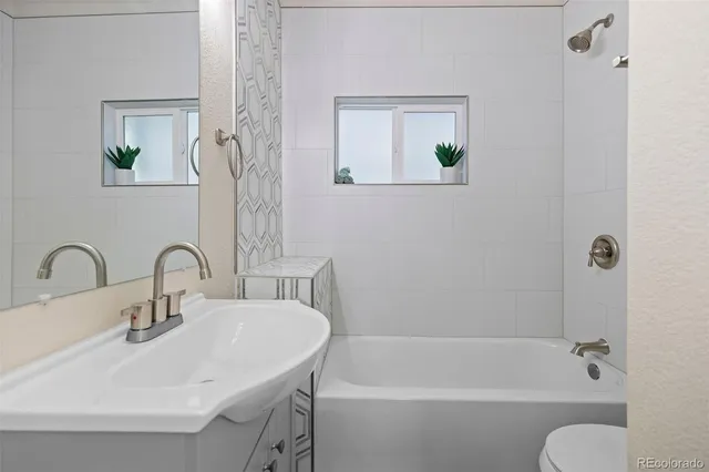 a bathroom with a sink mirror bathtub and toilet