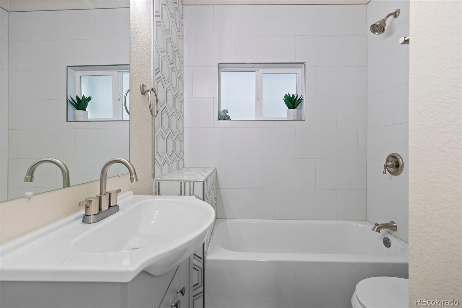 146 Stuart Street Denver, CO 80219 - Photo 17 of 29 a bathroom with a sink mirror bathtub and toilet