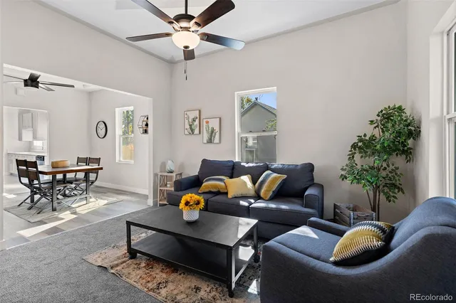 a living room with furniture a chandelier and a potted plant