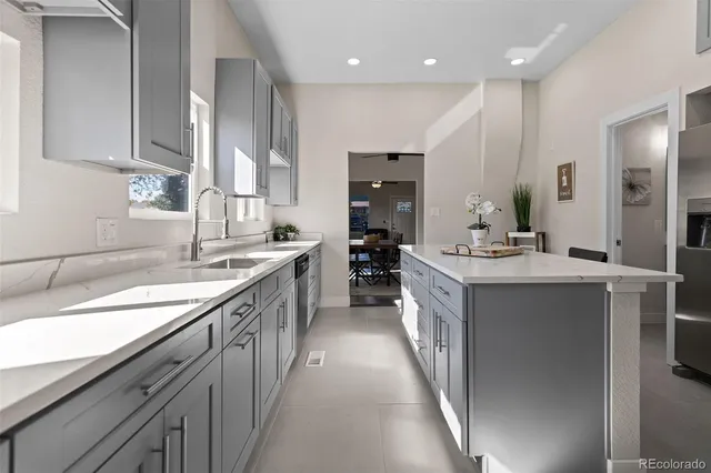 a large kitchen with stainless steel appliances kitchen island granite countertop a sink and cabinets