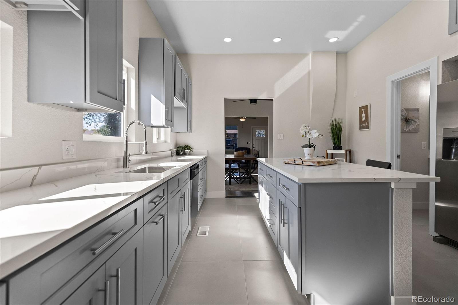 146 Stuart Street Denver, CO 80219 - Photo 5 of 31 a large kitchen with stainless steel appliances kitchen island granite countertop a sink and cabinets