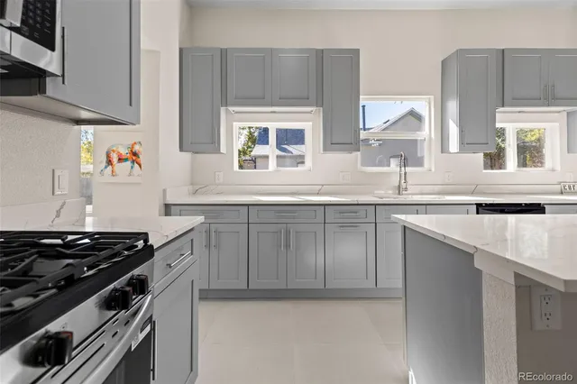 a kitchen with stainless steel appliances a sink stove and cabinets