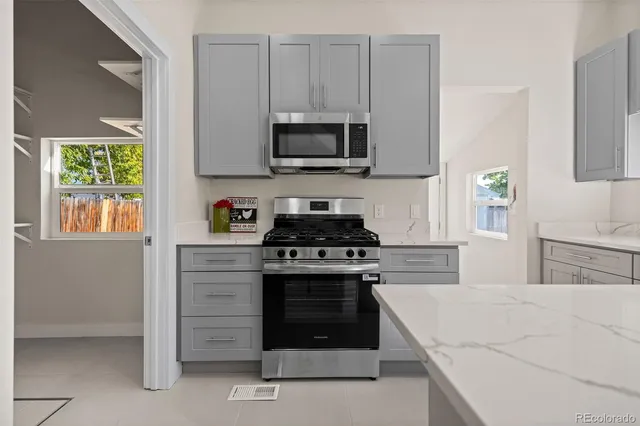 a kitchen with stainless steel appliances granite countertop a stove and a microwave