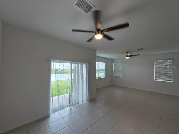 en empty room with windows and ceiling fan