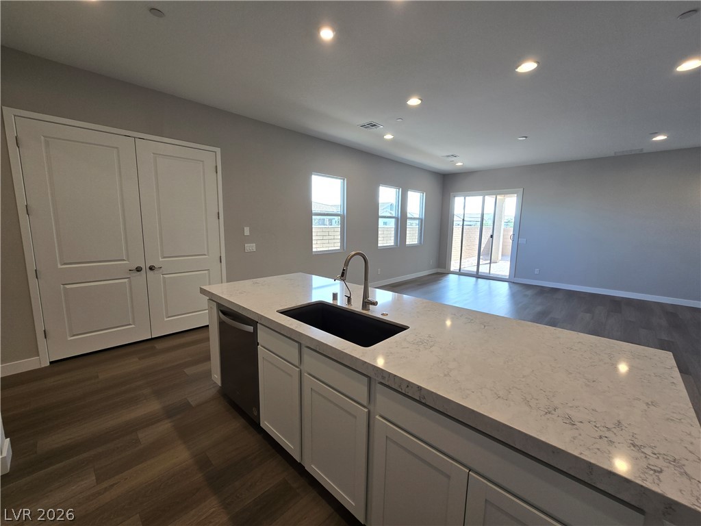 852 Weston Ridge Street Henderson, NV 89011 - Photo 7 of 28 A spacious kitchen with a large island and ample counter space flows into a luminous living area.