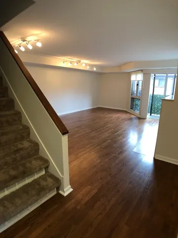 a view of entryway and hall with wooden floor