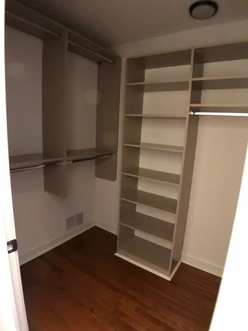 a view of walk in closet with empty racks