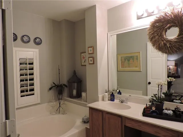 a bathroom with a tub sink and mirror