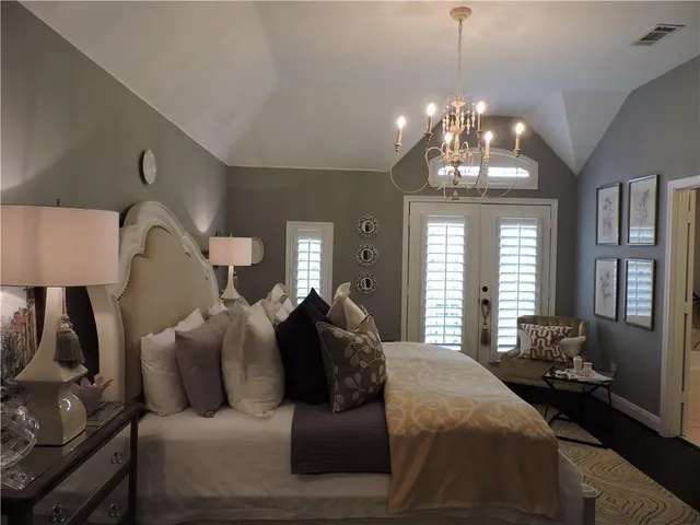 a large bed sitting in a bedroom next to a chandelier