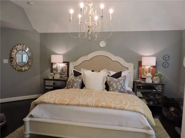 a bedroom with a bed and a chandelier