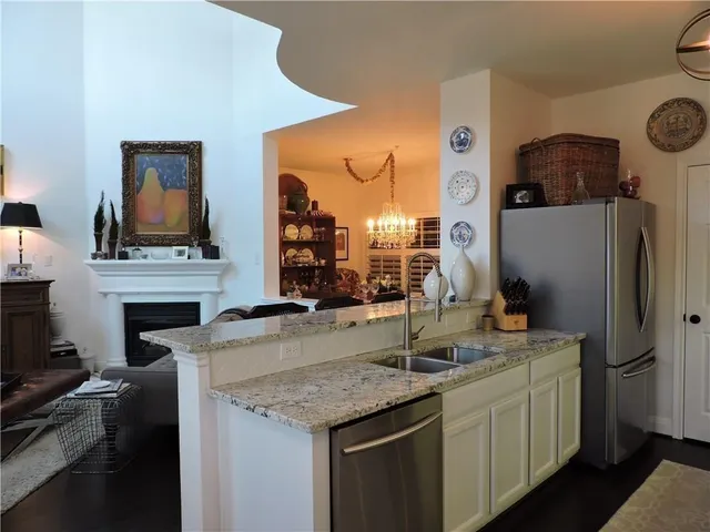 a kitchen with stainless steel appliances granite countertop a sink refrigerator and cabinets