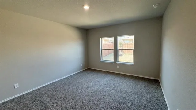 a large white kitchen with stainless steel appliances granite countertop a stove a sink a refrigerator and white cabinets with wooden floor