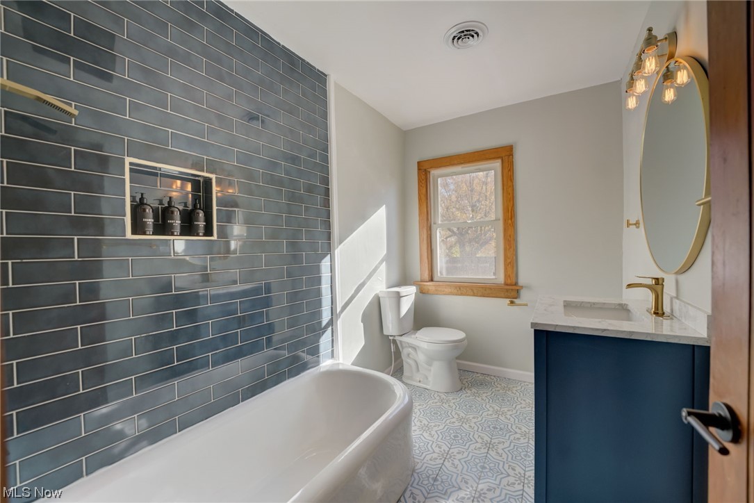 6197 Turney Road Cleveland, OH 44125 - Photo 12 of 35 Bathroom featuring a bath to relax in, toilet, oversized vanity, and tile flooring