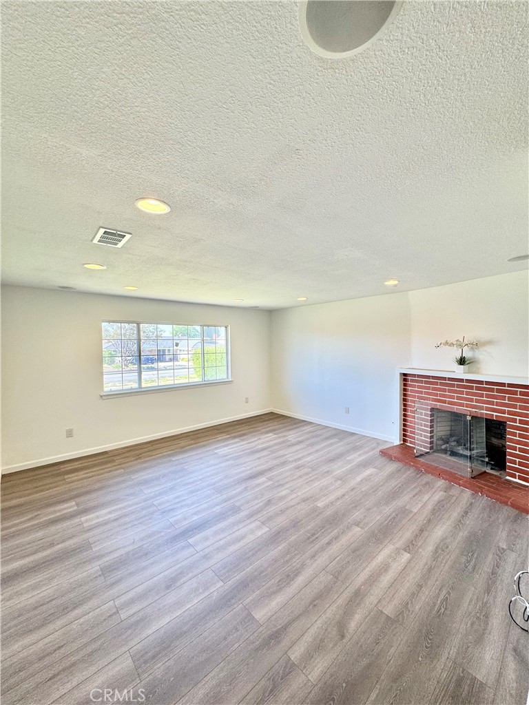 9364 Langston Street Rancho Cucamonga, CA 91730 - Photo 2 of 17 a view of an empty room with wooden floor and a fireplace