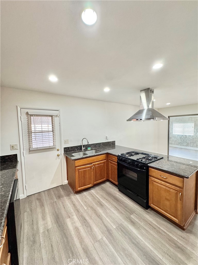 9364 Langston Street Rancho Cucamonga, CA 91730 - Photo 3 of 17 a large kitchen with granite countertop a stove top oven sink and cabinets