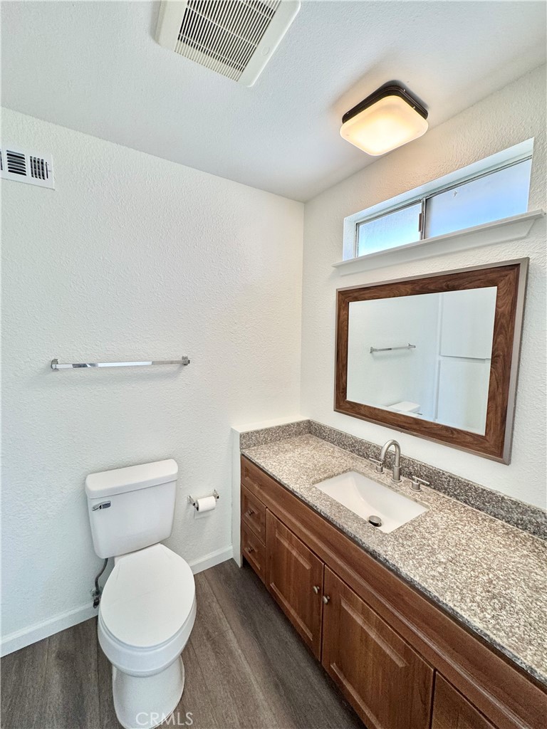 9364 Langston Street Rancho Cucamonga, CA 91730 - Photo 9 of 17 a bathroom with a granite countertop toilet sink and mirror