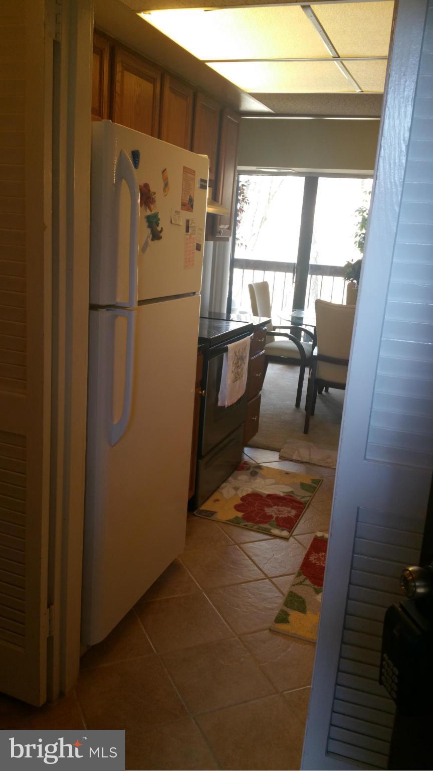2234 Castle Rock Square, Unit 11C Reston, VA 20191 - Photo 6 of 30 a white refrigerator freezer and a stove sitting inside of a kitchen
